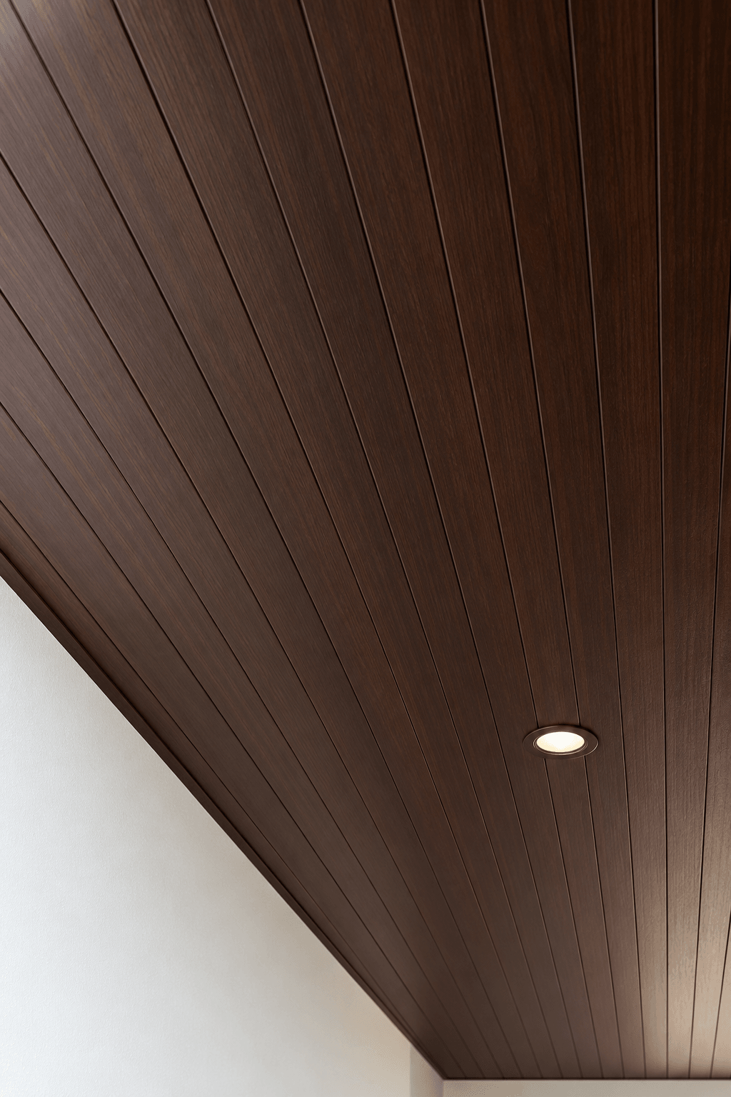 Close-up of woodgrain PVC ceiling strips with even grooves and a neat edge trim